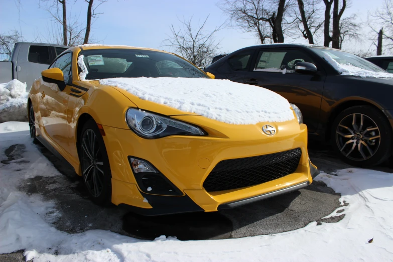 a car covered in snow and next to a truck