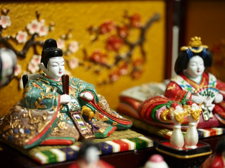 dolls are sitting on trays with asian decorations