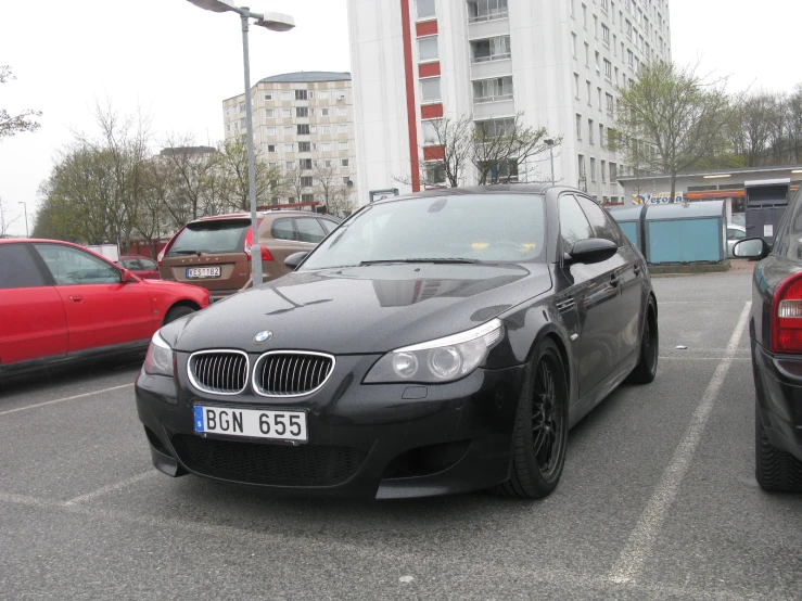 a car parked in a parking lot next to cars