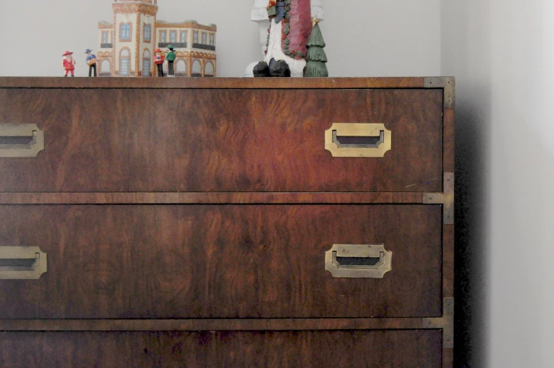 an old chest of drawers with dolls on top