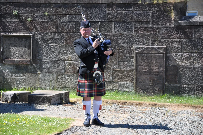 a man in plaid pants is playing bagpipes