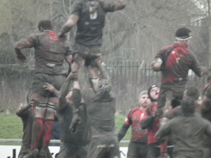 a rugby team jumping into the air as they play