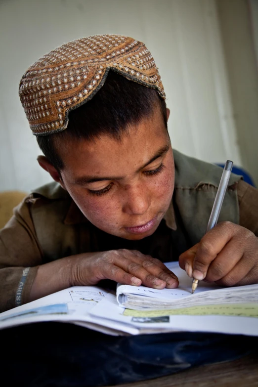 a  studying a book with his pen in hand