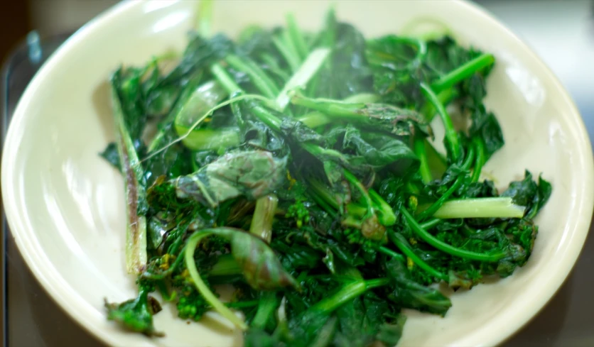 a bowl of vegetables is served on a plate