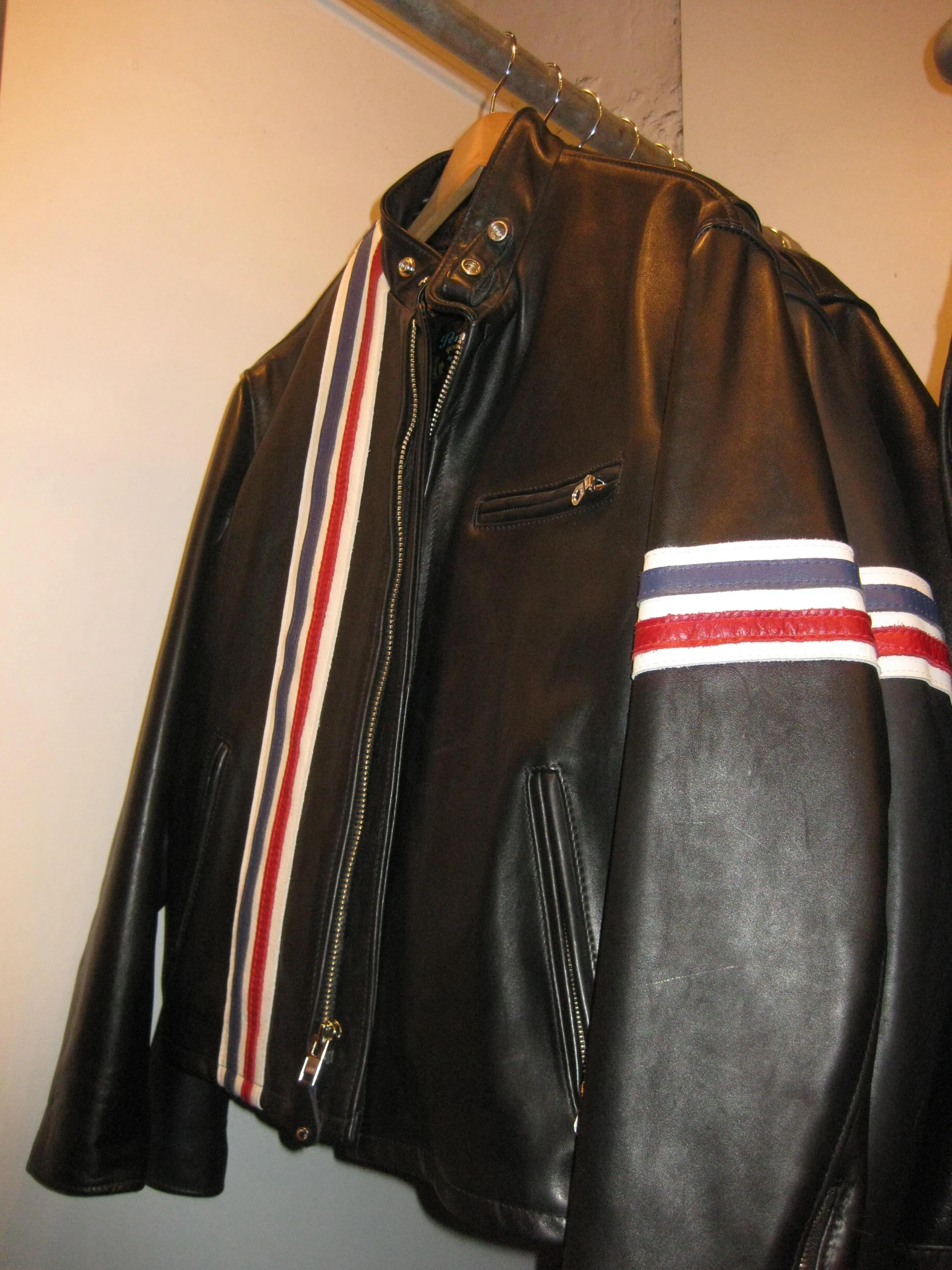 the jacket and other clothing are being hung on a coat rack