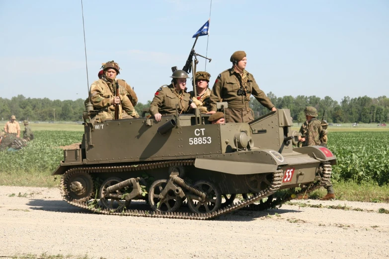 some men riding on top of an army tank