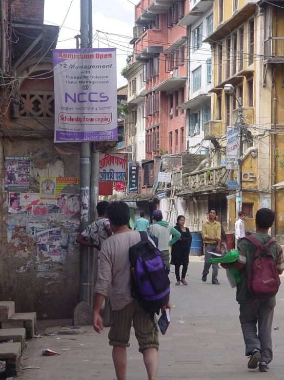 two guys are walking down the street in front of shops