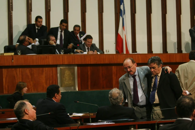 two men stand in front of an audience at a court