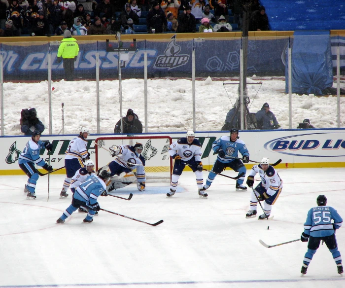 a hockey game with the referee behind the goalie