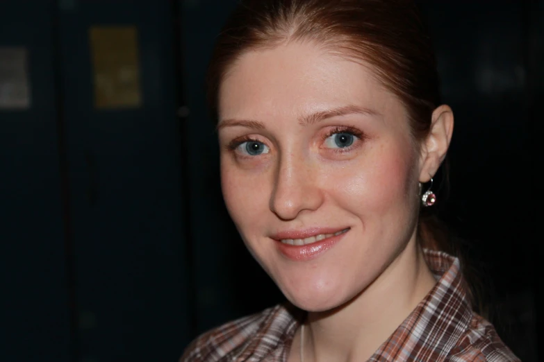 a woman with a pair of diamond earrings smiles at the camera