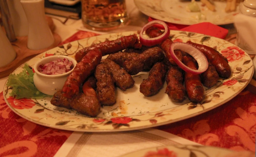 a plate topped with sausage and onions on top of a table