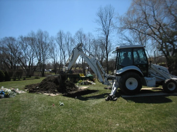 a tractor on a grass field with other construction equipment