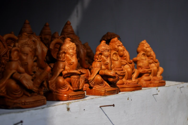 a line of carved wooden ganeshh