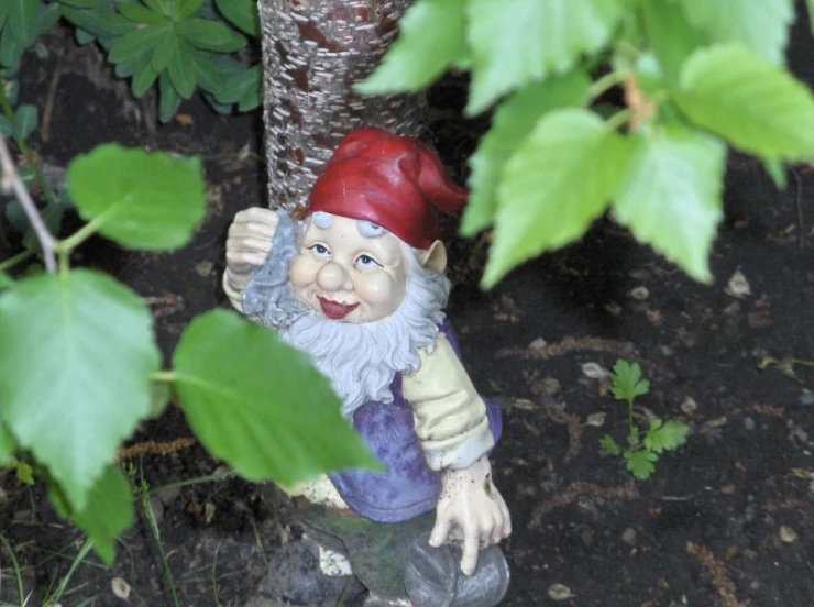 a garden gnome has the eyes closed and is holding the red cap