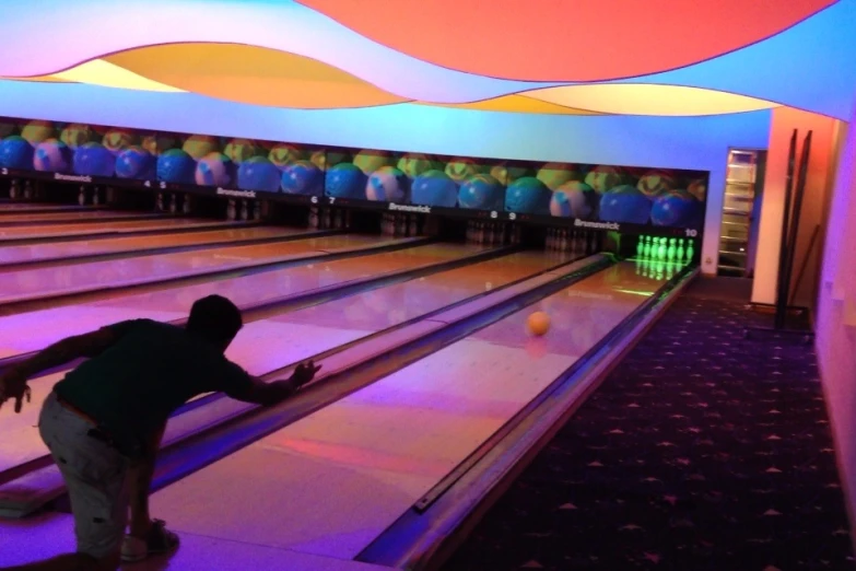 a man leaning down to a bowling alley