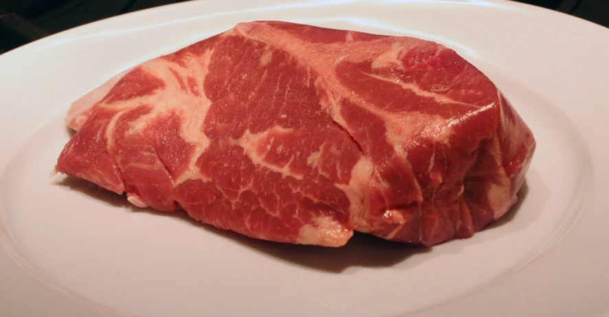 sliced meat sitting on a plate on top of a table