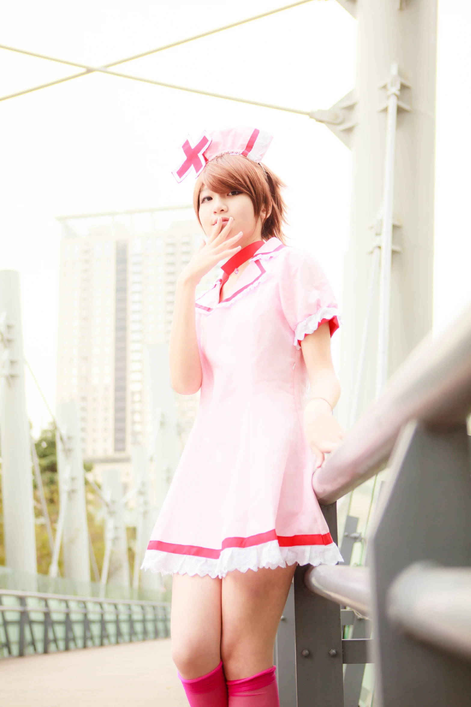 a japanese woman dressed up in a pink outfit standing on the bridge