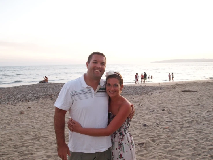 a man and woman are hugging on the beach