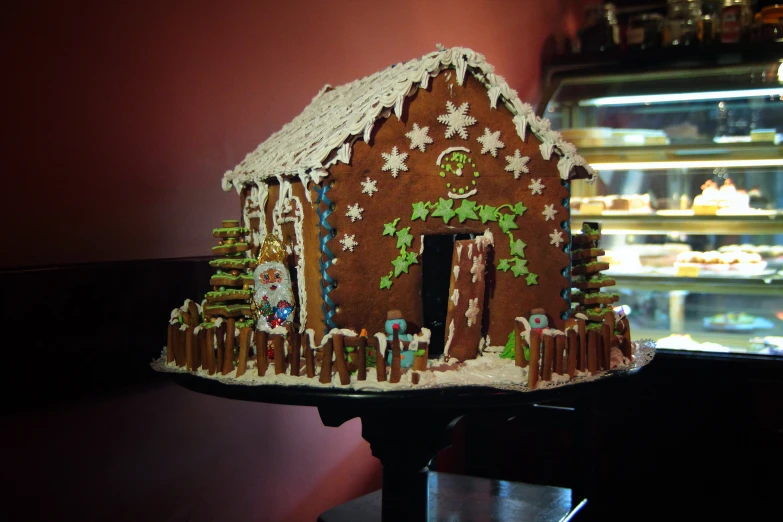 a gingerbread house made by hand with trees and stars on top