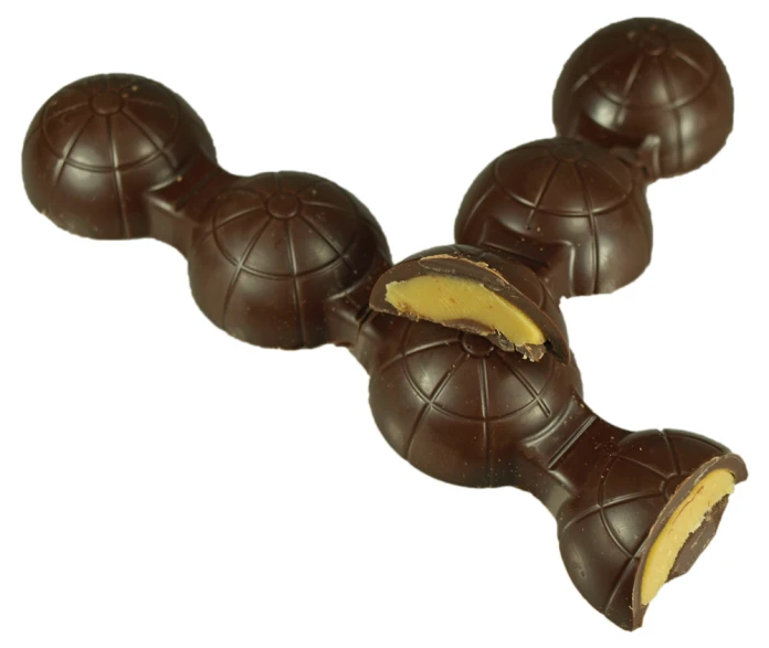 a chocolate candy ball has been cut open and pieces of it are being held in the other direction