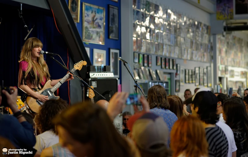 a beautiful blond girl singing into a microphone at a concert