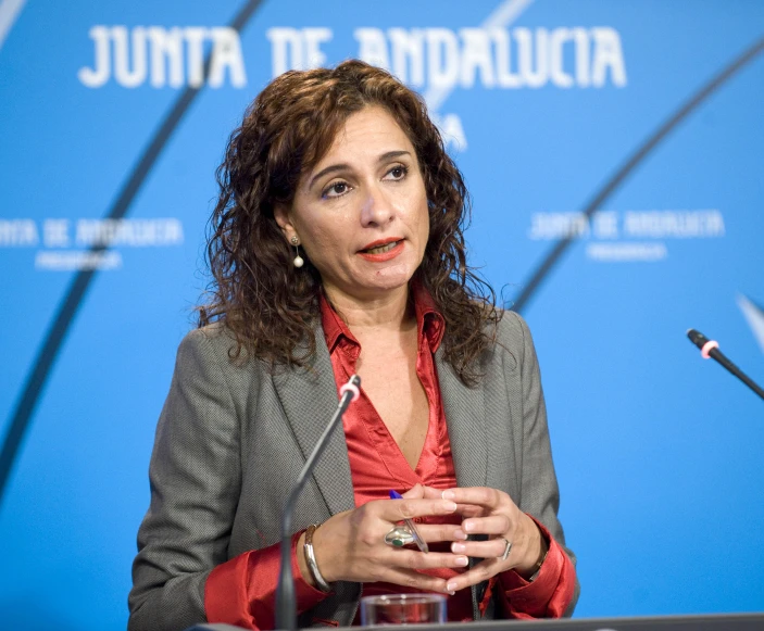 a woman sitting at a table with a microphone