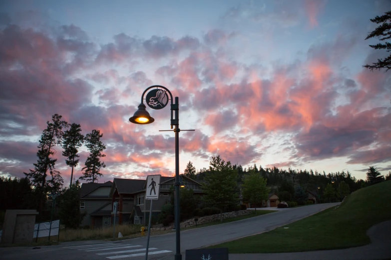 the clock on the street lamp has the sky in the background