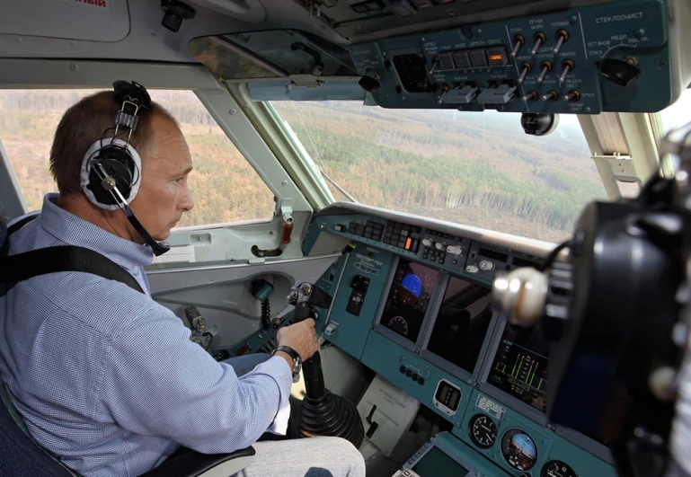 the pilot is sitting in the cockpit with headphones on