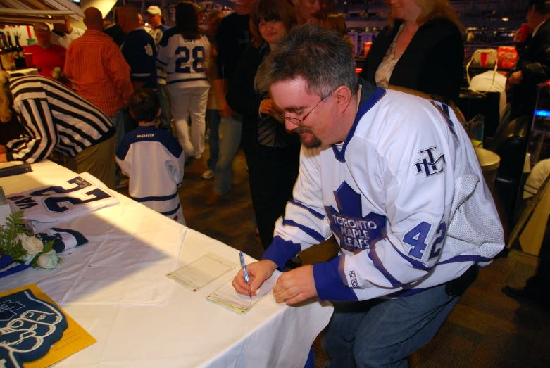 a baseball player signing an autograph on a table