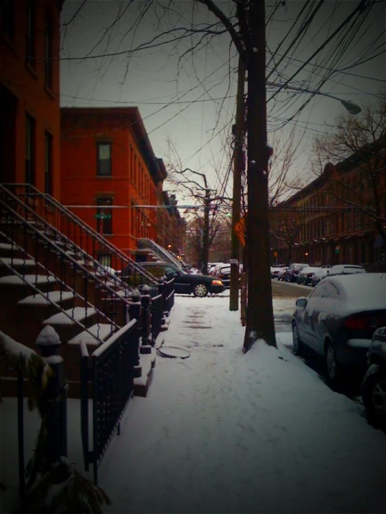 a street filled with snow and parked cars