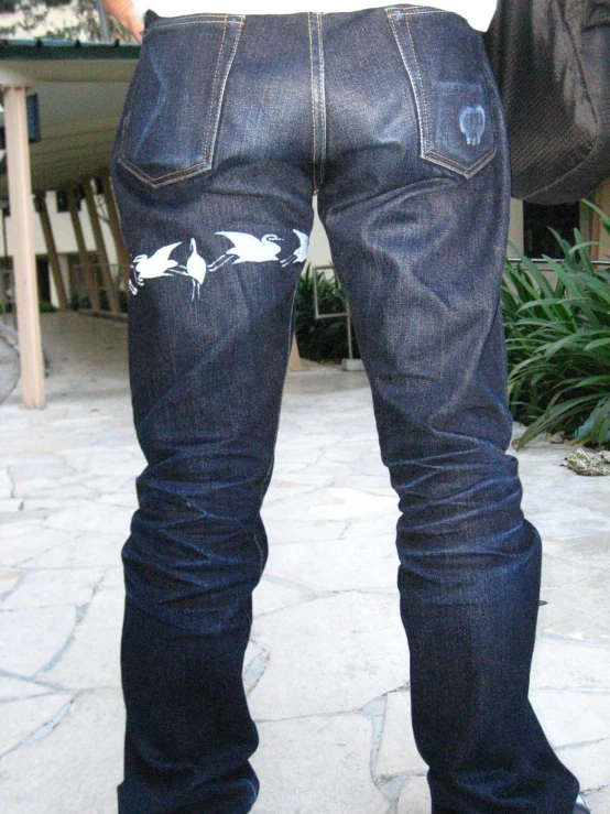 someones jeans with sharks drawn on them
