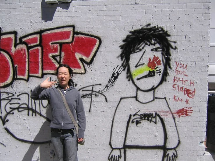 a guy is standing against the wall with a graffiti