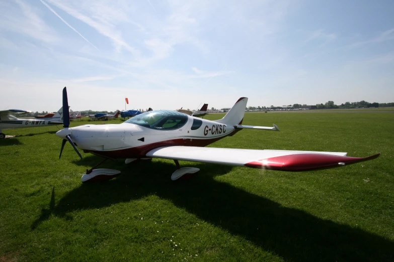 a small white airplane sitting in the middle of a field