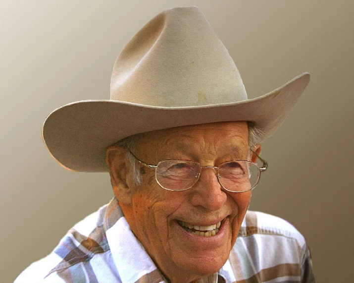 an elderly man wearing a hat smiling