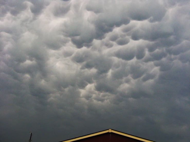 a red building surrounded by dark clouds in the sky