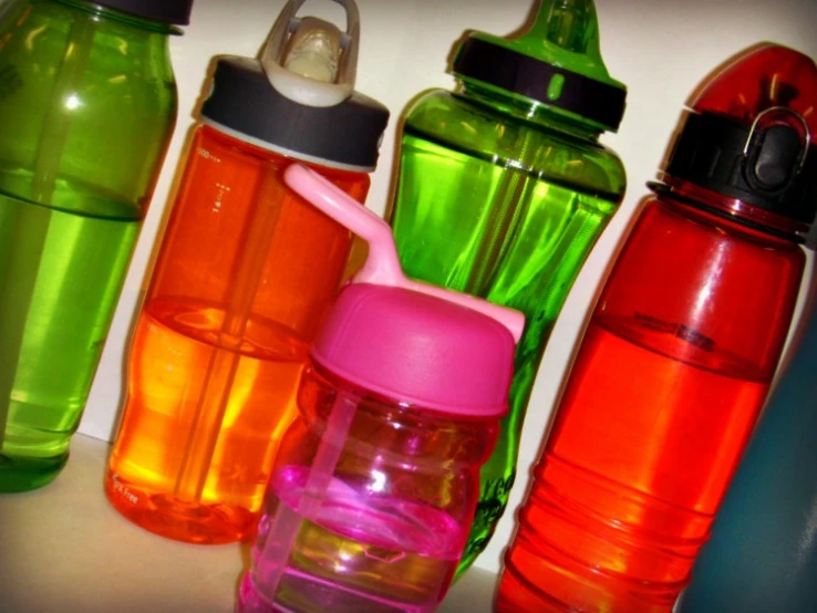 a group of colorful water bottles sitting on top of a table