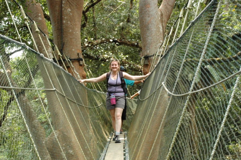 a woman walking on a walkway suspended bridge