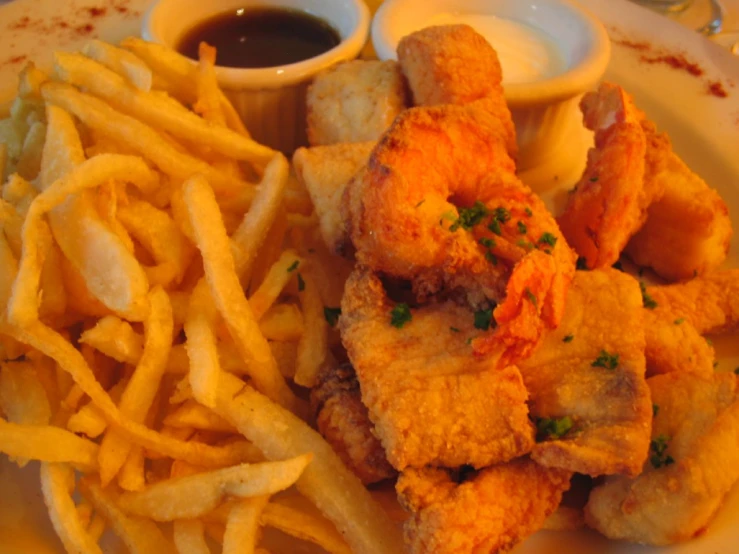 some fried chicken sticks and french fries with sauce on a plate