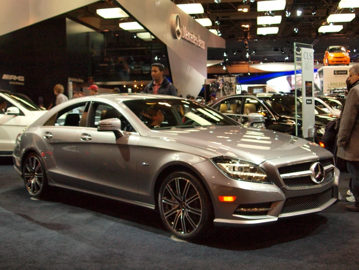 a man is standing in front of two mercedes cars