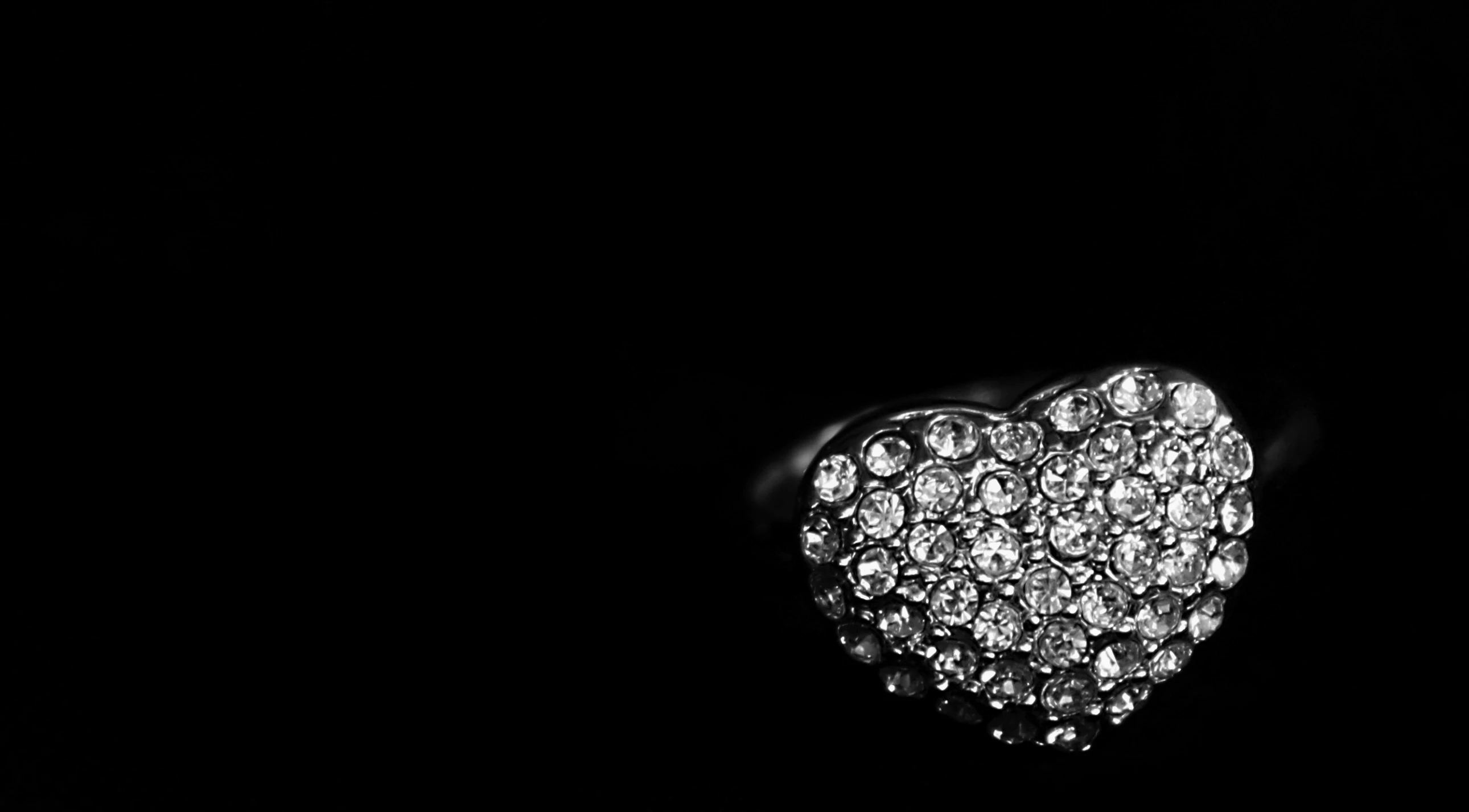 an open heart shaped ring in a black background