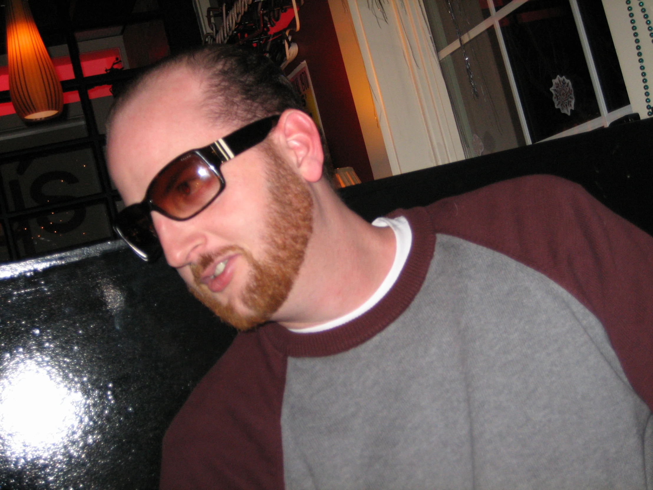 a man with dark sunglasses sitting in front of a table