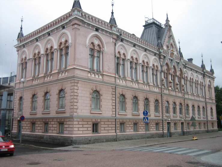 the large brown and beige building has arched windows