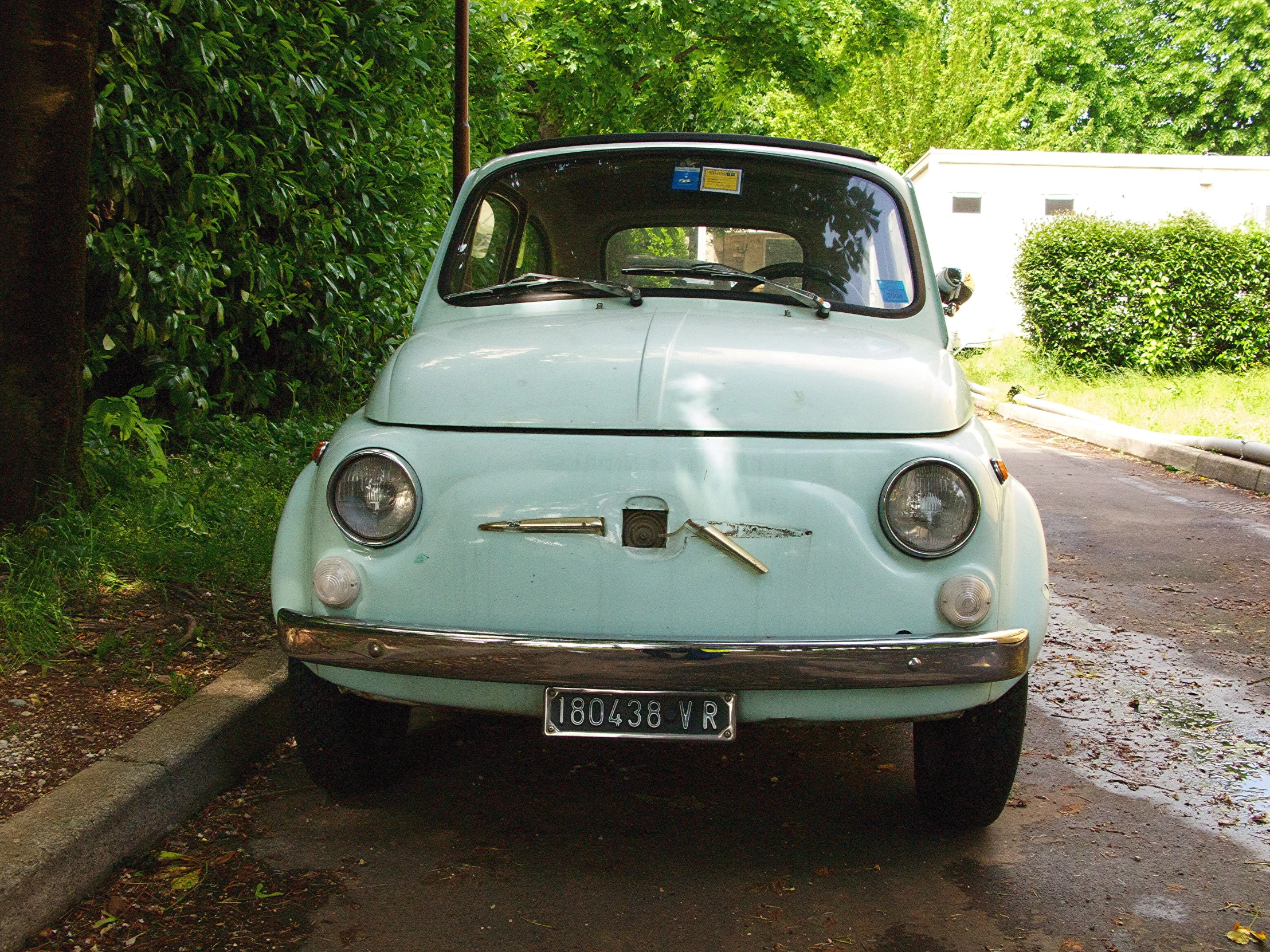 a car is parked in the street near the grass