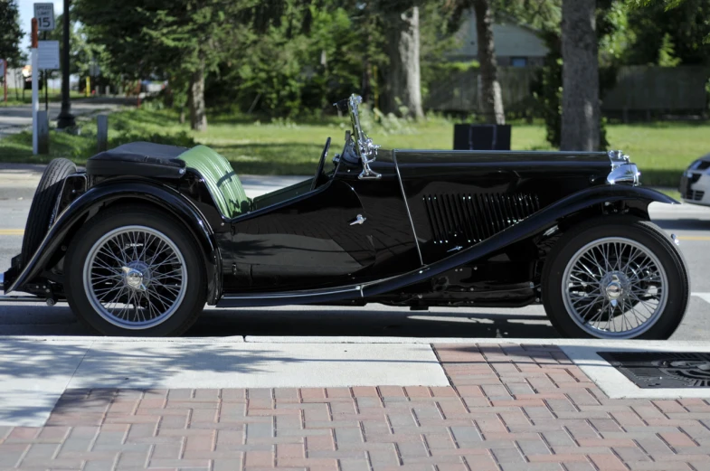 an old classic car is parked on the side of the street