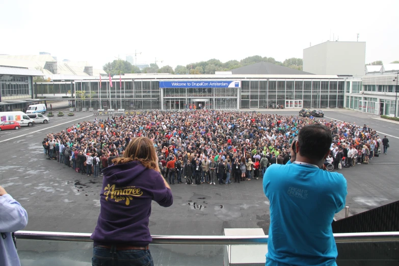 a large crowd watches as people stand in front of an empty lot