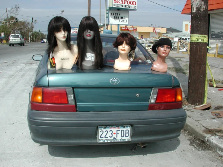 three wigs sit on the back of a car