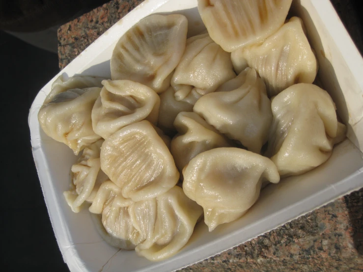 a tray filled with dumplings, sitting on a table