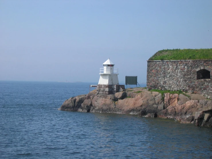 there is a small light house next to some water