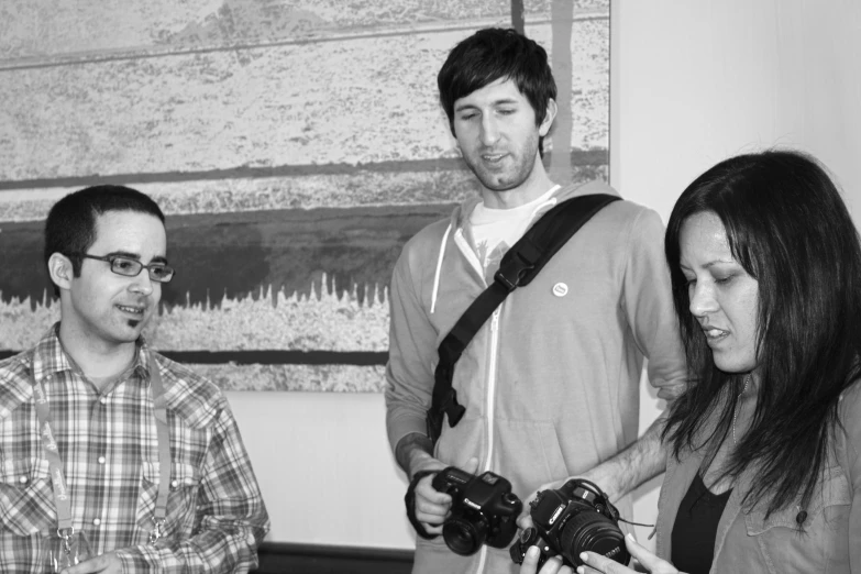 four people taking pictures with their digital cameras