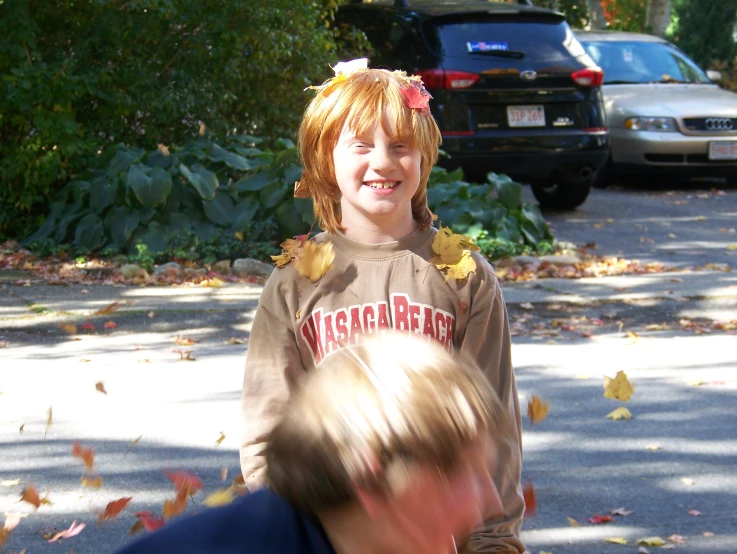 two children outside near each other and some cars